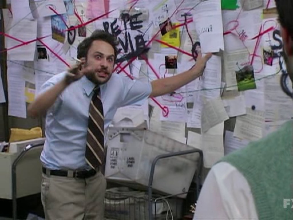 Charlie from It's Always Sunny In Philadelphia, pointing to a conspiracy board with an intense look on his face